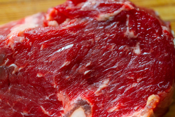 Shots  of a sliced raw fresh rump steak with fat on the steak on a wooden board - Fotoğraf, Görsel