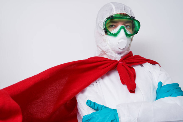 Doctor is wearing PPE - costume, gloves and surgical face mask in superhero cape. - Фото, зображення