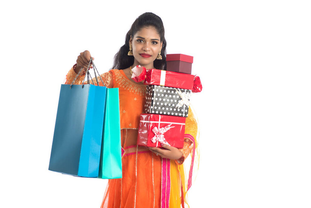 Beautiful woman carrying many shopping bags and gift Box on a white background. - Foto, imagen