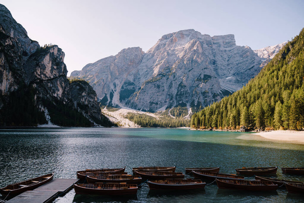 Empty wooden boats moored on the Lago di Braies on the background of rocky mountains and forest. Braies lake in the Dolomites in South Tyrol, Italy, a municipality of Braies, in the Prague Valley. - Foto, Bild
