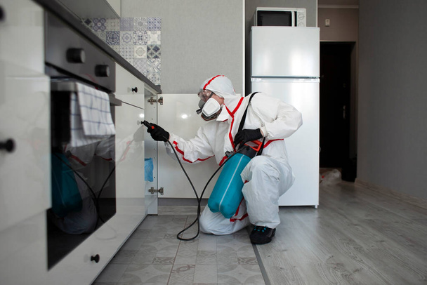 control de plagas. Desinfección de locales contra insectos y roedores por medios químicos, un trabajador sanitario con un spray en el fondo del apartamento
 - Foto, imagen