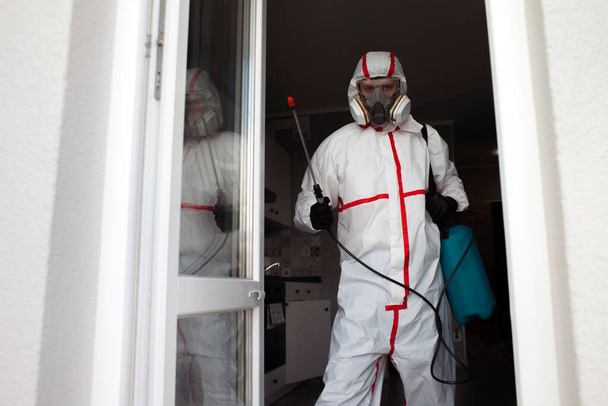 pest control. Worker in protective suit with spray gun, chemical disinfection of premises, copy space - Foto, Imagen