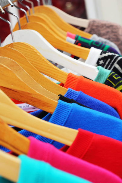 Loja camisas colorido tecido pendurado em um rack
. - Foto, Imagem