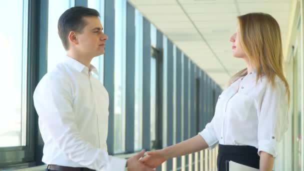 De zakenman en vrouw die elkaar de hand schudden in een modern kantoor. Zakelijke collega 's kantoormedewerkers bespreken project - Video