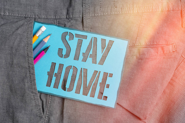 Konzeptionelle Handschrift, die Stay Home zeigt. Geschäftsfotos, die zeigen, dass Sie nicht für eine Aktivität ausgehen und im Haus oder zu Hause bleiben, Schreibgeräte und blaues Notizpapier in der Hosentasche. - Foto, Bild