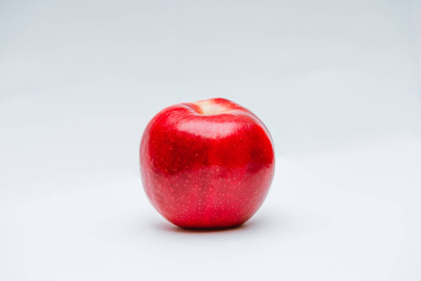 Спелые красные с точками и коричневый хвост яблоко изолированы на белом фоне
 - Фото, изображение