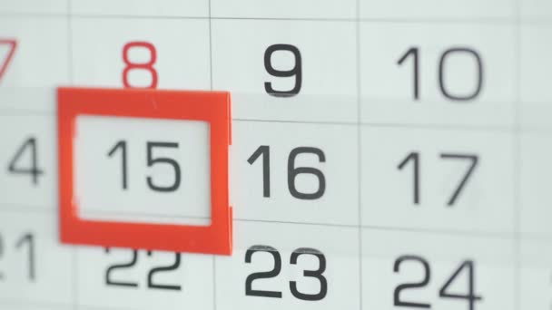 女性のオフィスでの手は、壁のカレンダーで日付を変更します。変更15～16 - 映像、動画