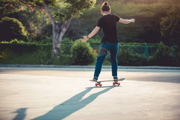 Skateboarder skateboarding at morning outdoors and doing tricks - Foto, Imagem
