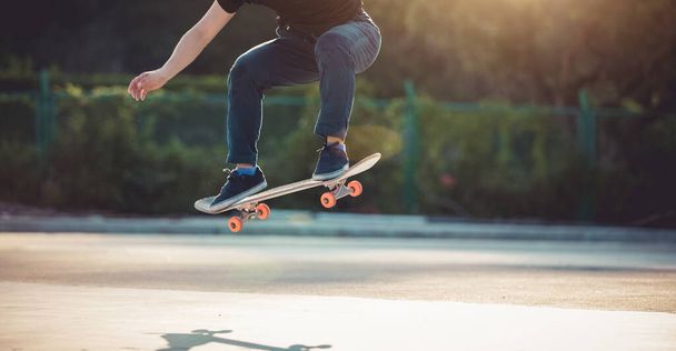 Skateboarder skateboarding at morning outdoors and doing tricks - Fotó, kép