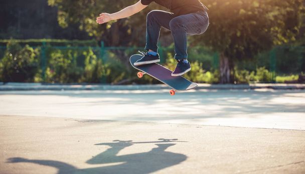 Skateboarder skateboarding at morning outdoors and doing tricks - Фото, изображение