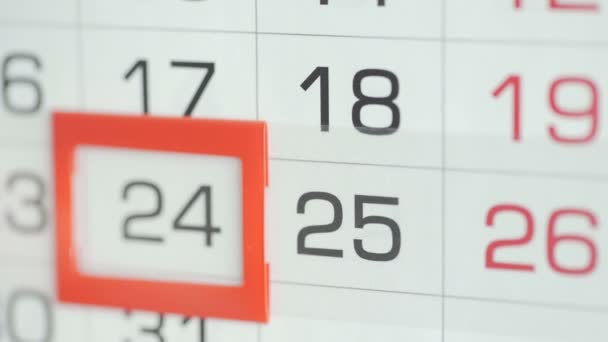 女性のオフィスでの手は、壁のカレンダーで日付を変更します。変更24～25 - 映像、動画