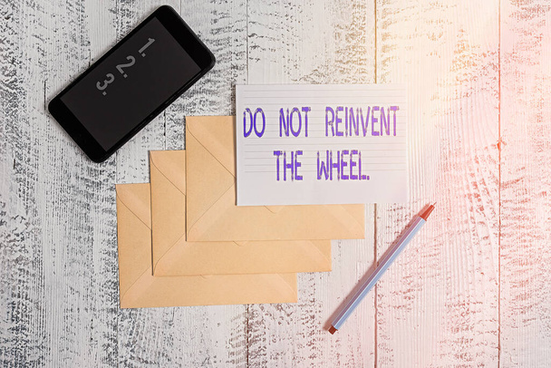 Käsikirjoitus "Älä keksi pyörää uudelleen". Business valokuva esittelee lopettaa päällekkäisiä perusmenetelmä aiemmin tehty Kirjekuoret merkki sääntö paperi älypuhelin puinen tausta
. - Valokuva, kuva