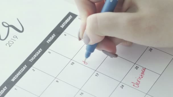 Macro de la mano escribiendo un plazo de palabra en el calendario bajo la fecha de 11
 - Metraje, vídeo
