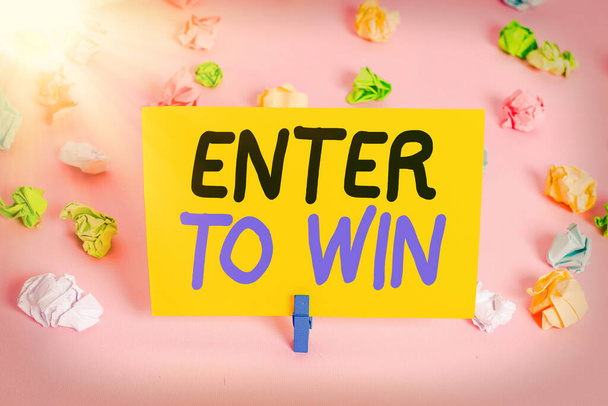 Text sign showing Enter To Win. Conceptual photo exchanging something value for prize or chance of winning Colored crumpled papers empty reminder pink floor background clothespin. - Fotografie, Obrázek