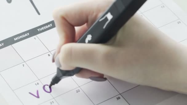 Donna scrittura a mano con penna in feltro viola sul calendario vacanza parola
 - Filmati, video