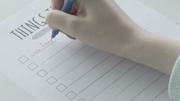 Młoda dziewczyna wypełniająca listę rzeczy do zrobienia w notatniku. - Materiał filmowy, wideo