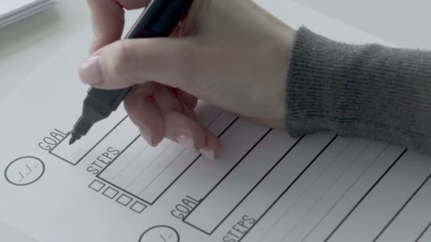 Egy nő, aki piros jelzéssel írja a célokat a góllistán. Nő írás szavak fogyni - Felvétel, videó