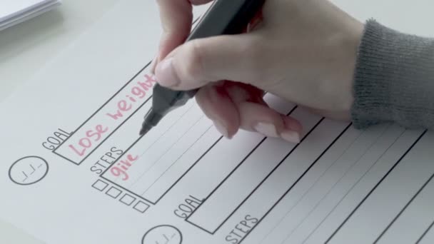 Frau schreibt Schritte mit roter Markierung auf Torliste. - Filmmaterial, Video