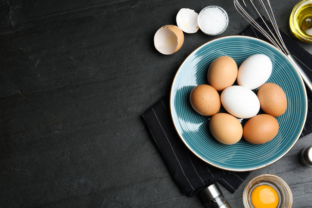 Flat lay composition with chicken eggs on black table. Space for text - Foto, Bild