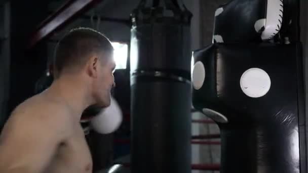 4K 60p Caucasian Male Boxer Training at Urban Gym. Practicing Hits on Punch Bags Pads - Materiał filmowy, wideo
