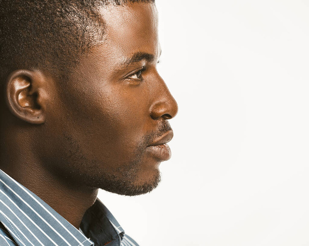 Serious African american man looks confident. Close up profile of Attractive Dark-skinned guy isolated on white background. Copy space at right side. Toned image - Fotó, kép