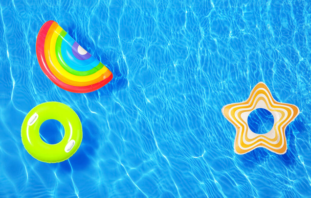 Différents anneaux gonflables flottant dans la piscine, vue de dessus
 - Photo, image