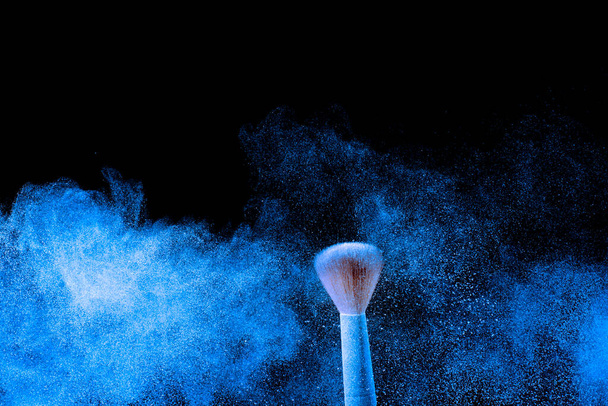 Cepillo de maquillaje con nube de salpicadura de polvo azul
. - Foto, Imagen