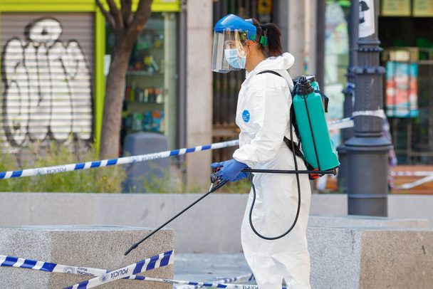 Madrid, España, 22 de mayo de 2020: Mujer trabajadora desinfectando las calles con equipos especiales para combatir el coronavirus
 - Foto, imagen