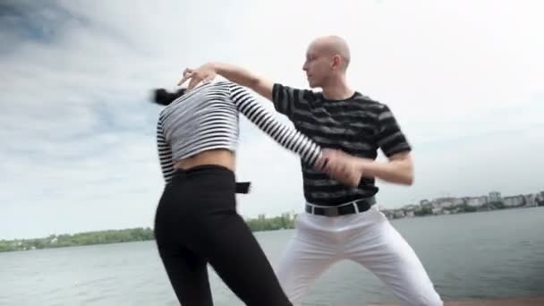 The couple in love dance social dance bachata pier on the lake, town horizon - Кадры, видео