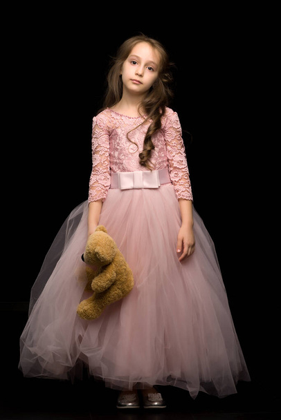 Charming Girl in Nice Pink Dress. Isolated Black Background - Fotoğraf, Görsel