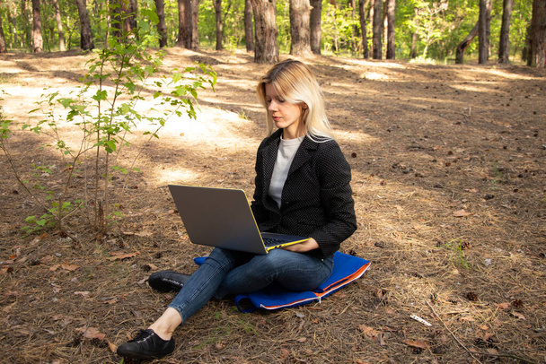 ukrainienne fille est assis avec un ordinateur portable dans une forêt de conifères quarantaine
 - Photo, image