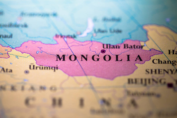 Shallow depth of field focus on geographical map location of country Mongolia in Asia continent on atlas - Photo, Image