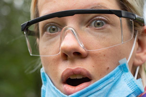 menina em uma máscara médica e óculos na rua close-up durante uma pandemia
 - Foto, Imagem