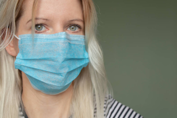 молодой украинки в медицинской маске на лице во время карантинной пандемии 2020 года дома
 - Фото, изображение