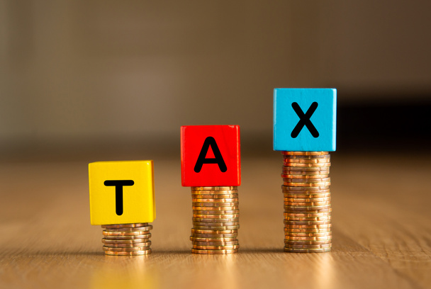 Налоговый концептуальное изображение: Деревянные блоки и монеты расположены со словами TAX
 - Фото, изображение