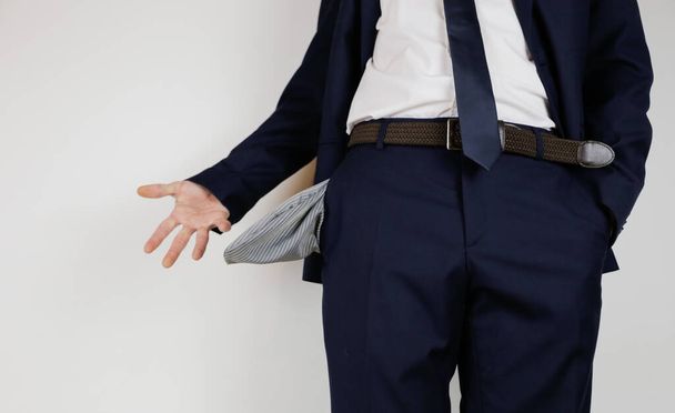 Ένας άντρας με κοστούμι, άδειασε τις τσέπες του. Οικονομική κρίση. Πτώχευση στις επιχειρήσεις. Ένας επιχειρηματίας χωρίς χρήματα. - Φωτογραφία, εικόνα