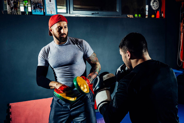 Yoğunlaşmış profesyonel bir boksör kum torbasına vurur.. - Fotoğraf, Görsel