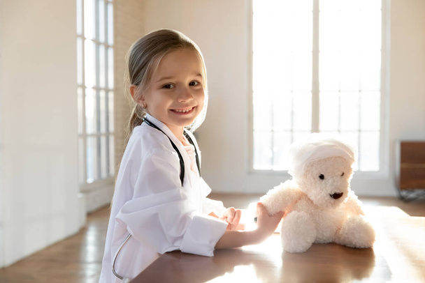 Portret van lachend meisje genezen pluche speelgoed - Foto, afbeelding