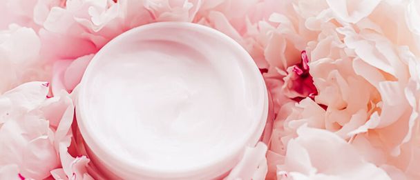 Luxe βάζο καλλυντική κρέμα ως αντιγηραντικό προϊόν ρουτίνας φροντίδας του δέρματος στο παρασκήνιο της παιώνιας λουλούδια, ενυδατική κρέμα σώματος και το εμπορικό σήμα ομορφιάς - Φωτογραφία, εικόνα