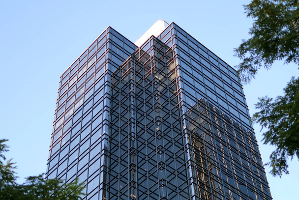 Movimiento del cielo azul con fachada de vidrio reflejado iluminado en el moderno edificio de oficinas
 - Foto, imagen