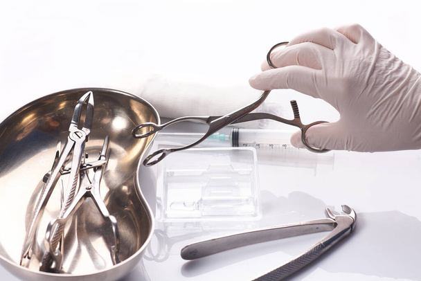 Primo piano dentista mano sta selezionando uno strumento utilizzato per il trattamento dei denti paziente. - Foto, immagini