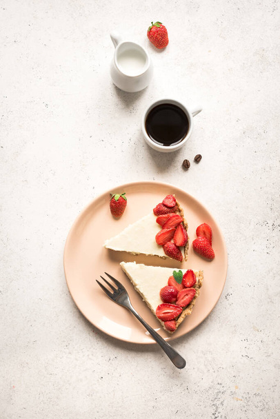 Cheesecake with strawberries on plate, top view, copy space. Slice of homemade cheese cake and sauteed berries, delicious desert. - Φωτογραφία, εικόνα