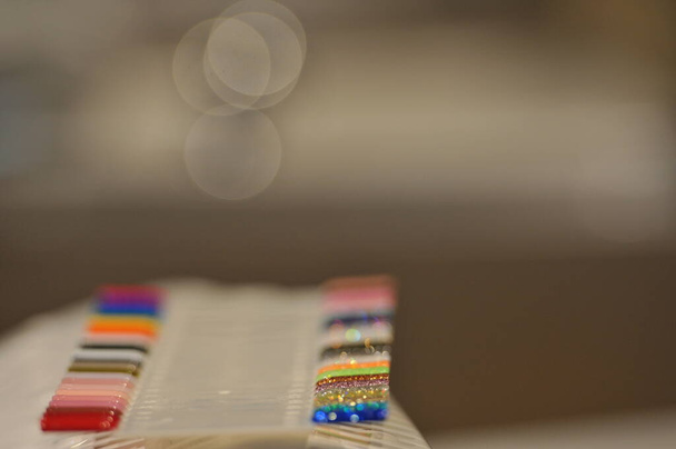 uñas artificiales de colores en estantes en salón de belleza
  - Foto, imagen