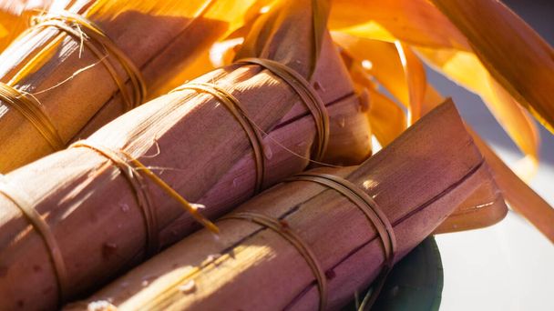 Ketupat lepet, ein besonderes Gericht, das anlässlich des Eid Mubarak / Ied Fitr-Festes in Indonesien serviert wird. Ketupat ist eine Art Knödel aus Reis, der in einem rechteckigen Behälter aus geflochtenem Palmblattbeutel verpackt ist. - Foto, Bild