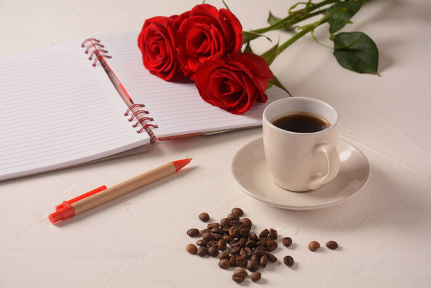 Cup of coffee, notebook, pen and rose flowers. Morning coffee break - Foto, immagini
