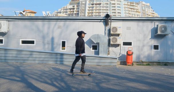 Giovane cavalcata maschile sul pattino longboard per le strade
 - Foto, immagini