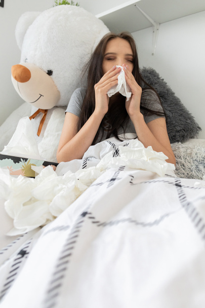 Eine schwere Erkältung verursacht Kopfschmerzen und die Notwendigkeit, ständig die Nase zu wischen. - Foto, Bild