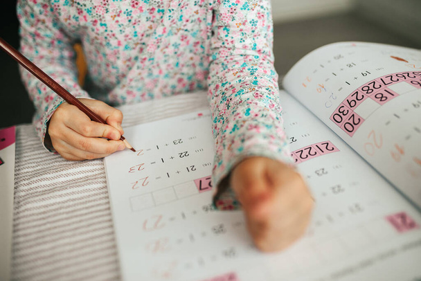 Cute five years girl learning math at home. Education and distance learning for kids. Homeschooling concept - 写真・画像