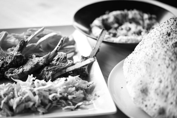 deliciosos pauzinhos de cordeiro grelhados com batatas fritas, molho pesto e mistura de alfaces
 - Foto, Imagem