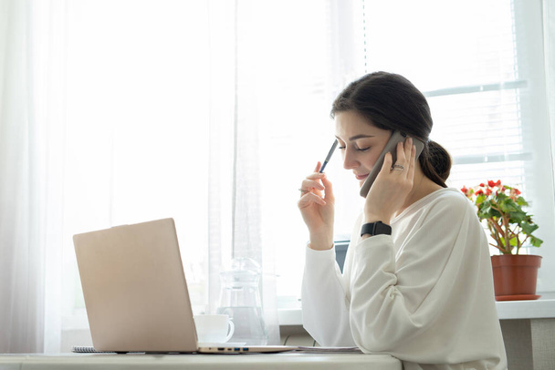 Bizneswoman konsultuje się telefonicznie z domu. Utalentowany menedżer zdalnie pracujący w laptopie czytający e-maile. Koncepcja pracy zdalnej i konsultacji telefonicznych - Zdjęcie, obraz